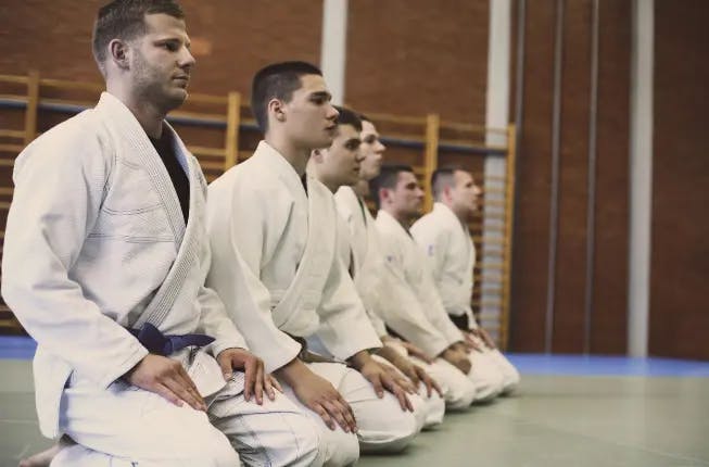 men in traditional martial arts uniform in mma gym 