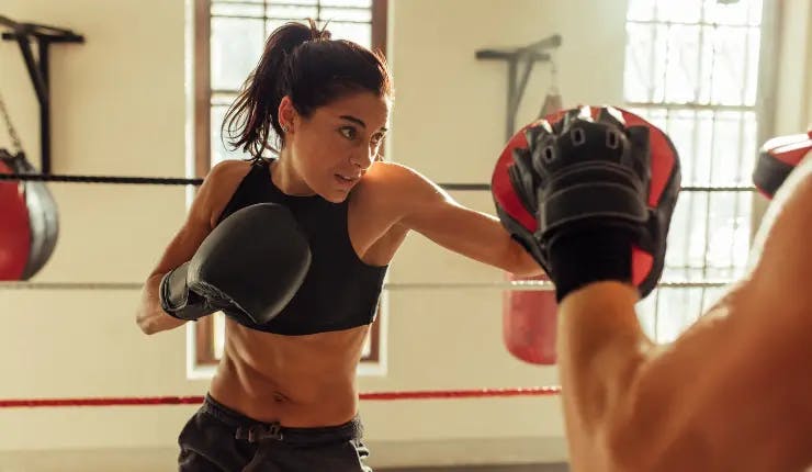 women training boxing in martial arts gym 