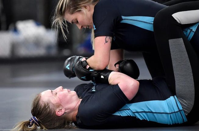 Alta women training martial arts ground work at a gym